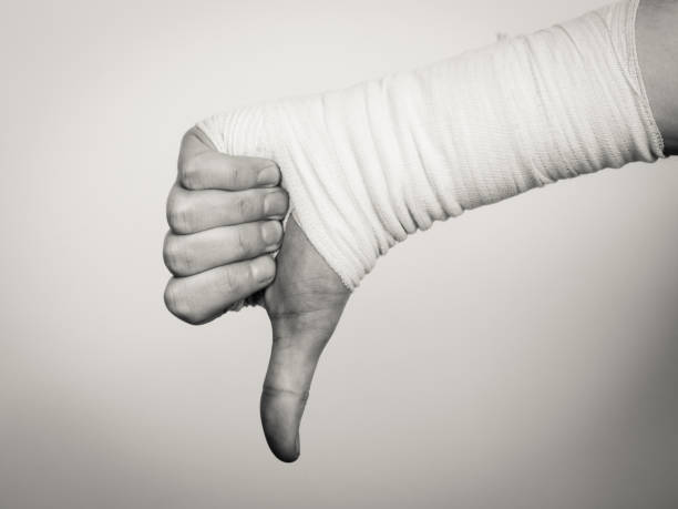 istock Male bandaged hand with thumb down sign. 840620954
