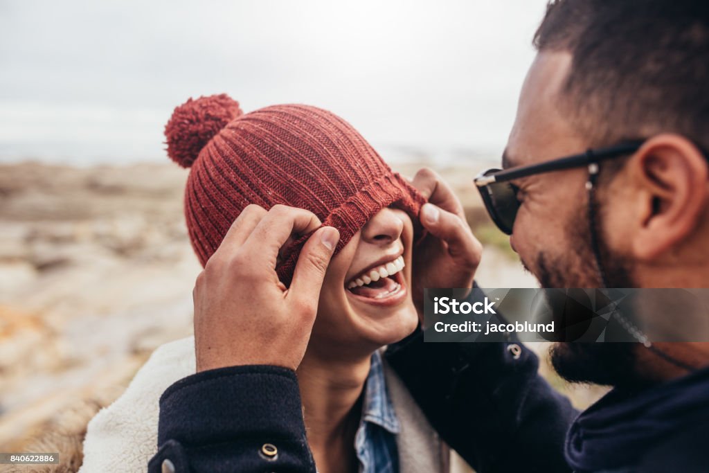 Loving couple having fun outdoors Loving couple having fun outdoors. Man covering eyes of woman with cap. Winter Stock Photo