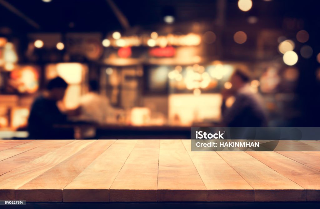 Wood table top with blur night cafe background Wood table top with blur light bokeh in night cafe background .Lifestyle and celebration concepts Crowded Stock Photo