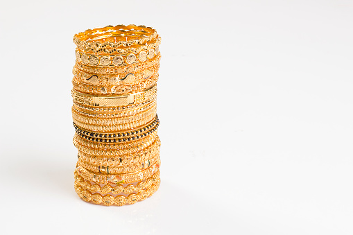 gold bangles and necklace isolated on white background