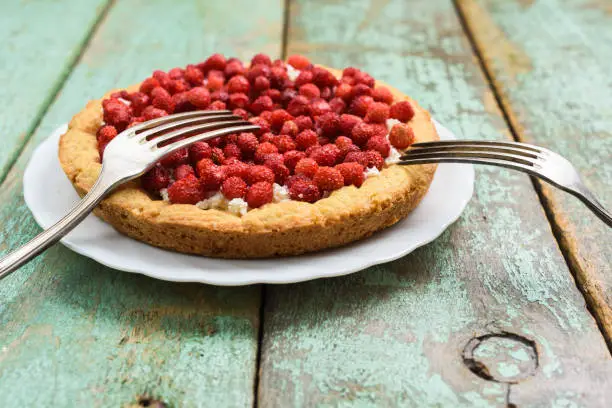 Wild strawberry tart with cottage cheese served with vintage forks with copyspace