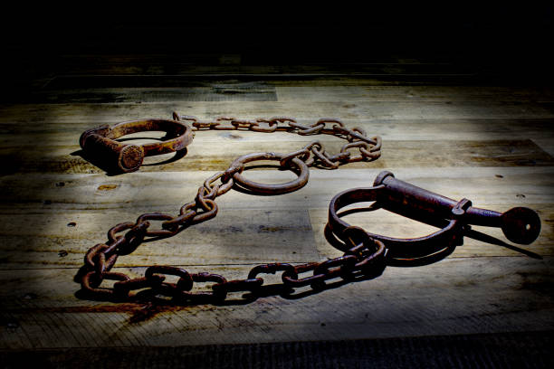 istock Old fashioned, vintage shackles on a rustic wooden background. 840631592