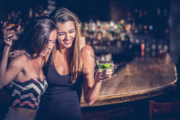 Girls night out Two young woman having martinis laughing sexy human beings stock pictures, royalty-free photos & images