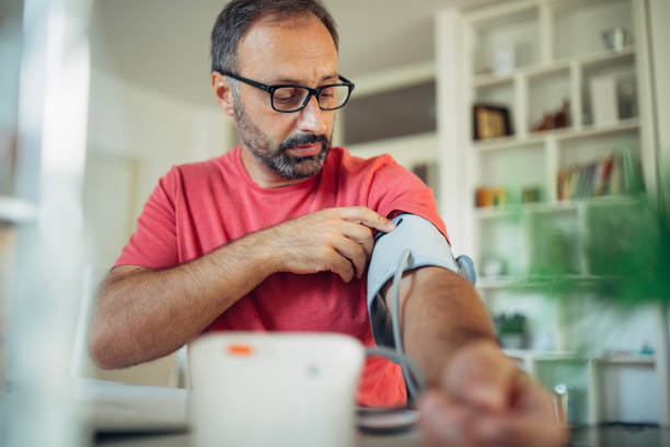 uomo che controlla la presure del sangue - indicatore di pressione sanguigna foto e immagini stock