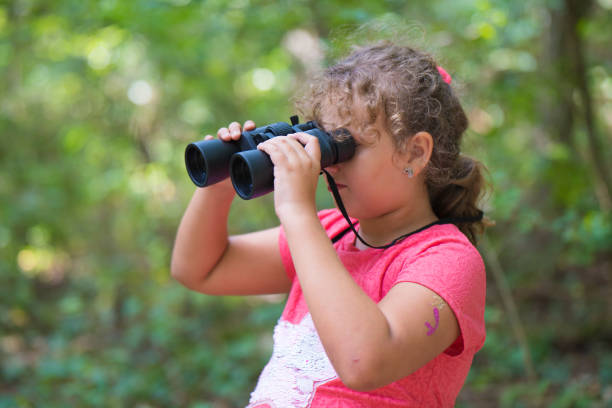 istock Young girl with a binocular in the forest 840635698