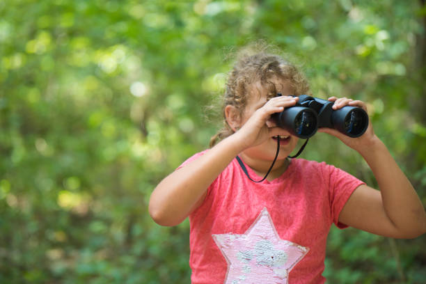 istock Young girl with a binocular in the forest 840635726