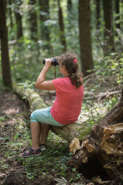 istock Girl using a field glass and pointing at something 840635746