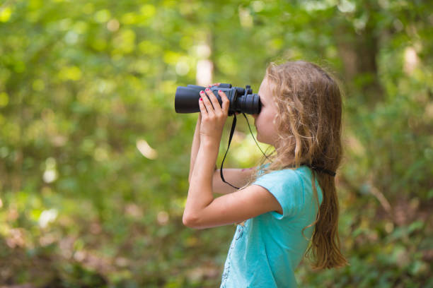 istock Young girl with a binocular in the forest 840635752