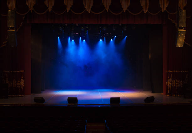 o palco do teatro iluminado por holofotes e fumaça do auditório - theatrical performance curtain stage theater stage - fotografias e filmes do acervo