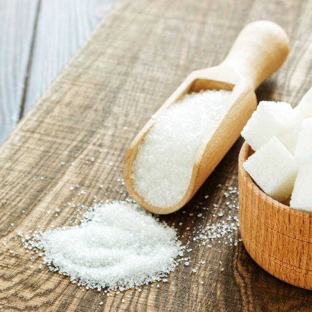 istock Wooden scoop and bowl with sugar on table, closeup 840636570