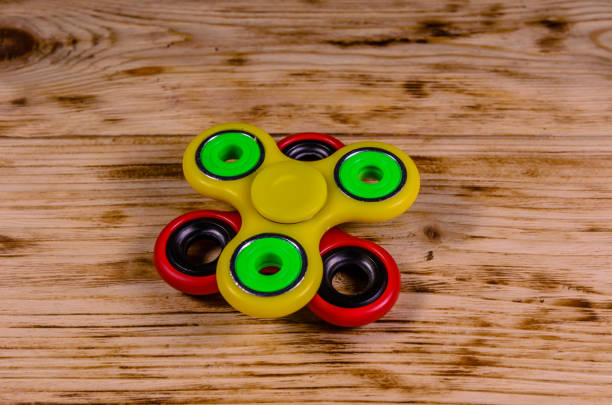 istock Two fidget spinners on wooden desk 840639346