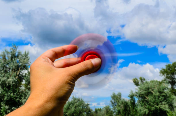 istock Red fidget spinner rotates in female hand 840639350