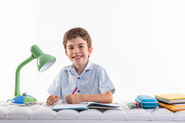 little schoolboy drawing in book isolated on white background
