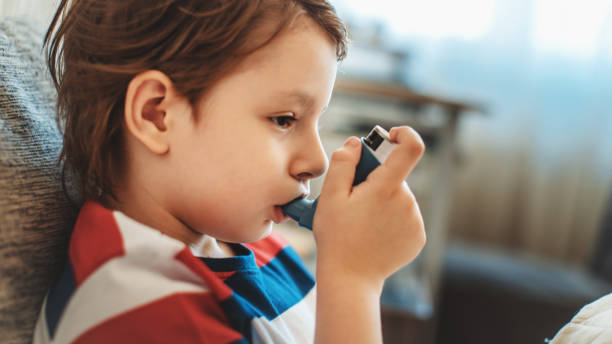 inhaler - asthmatic child asthma inhaler inhaling stock-fotos und bilder
