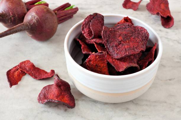 Bowl of healthy beet chips over white marble