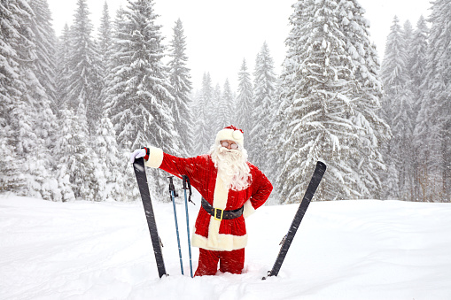 Santa Claus skiing in the mountains on snow in winter in Christmas. Christmas in the mountains.