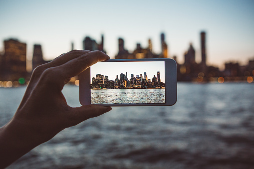 Shot of woman's hands photographing New York City skyline