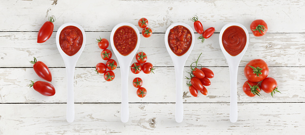 tomato sauce spoon with tomatoes and basil Isolated on wooden white background