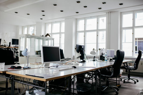uno spazio per uffici luminoso e moderno con computer - office furniture open plan desk foto e immagini stock