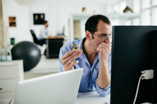 kantoor werknemer werkt op computer, terwijl met behulp van fidget spinner - handspinner stockfoto's en -beelden