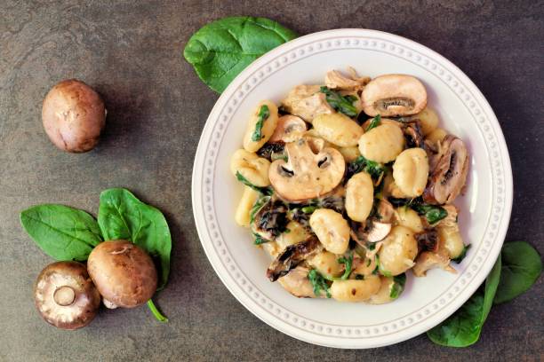 gnocchi med svamp sås, spenat & kyckling, ovanifrån på mörk sten - foton med kanada bildbanksfoton och bilder