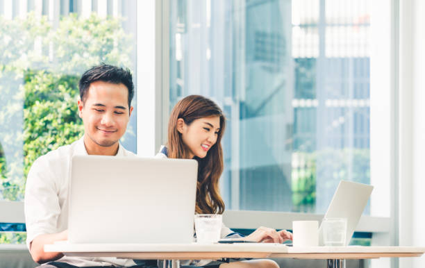 la giovane coppia asiatica o lo studente universitario che utilizza notebook per computer portatili lavorano insieme in caffetteria o campus universitario. tecnologia dell'informazione, stile di vita del caffè, riunione d'ufficio o concetto di e-learning - japanese ethnicity college student student asian ethnicity foto e immagini stock