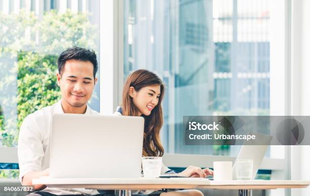 Young Asian Couple Or College Student Using Laptop Computer Notebook Work Together At Coffee Shop Or University Campus Information Technology Cafe Lifestyle Office Meeting Or Elearning Concept Stock Photo - Download Image Now