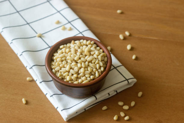 Pine nuts in a clay bowl on a wooden table