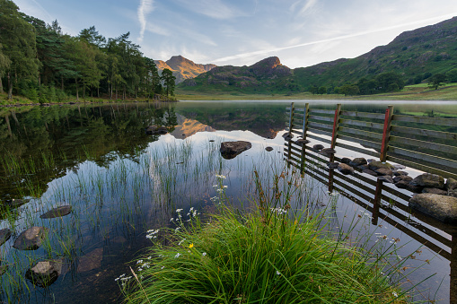 Peaceful morning at Blea Tarn in the Lake District with mirror like reflections.