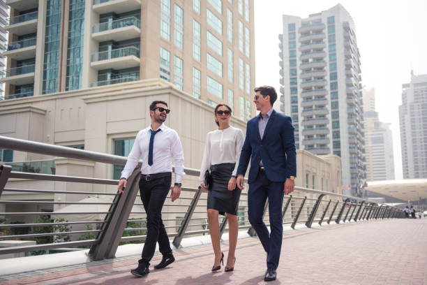 Enjoying a business travel Elegant businesspeople walking in a modern city. arabian sunglasses stock pictures, royalty-free photos & images