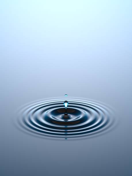 Water drop falling into water surface stock photo