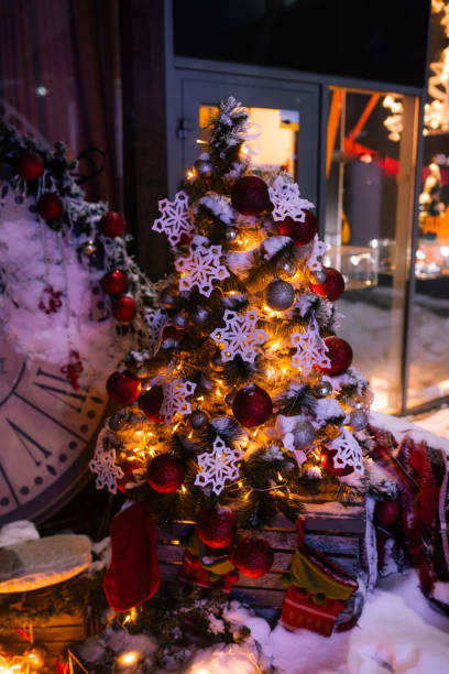 istock Christmas background with illuminated fir tree and fireplace, clock at house 840666176