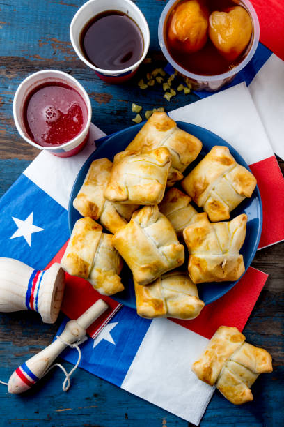 Chilean independence day concept. fiestas patrias. Chilean typical dish and drink on independence day party, 18 september. Mini empanadas, mote con huesillo, wine with toasted flour, chicha and tipical play emboque stock photo
