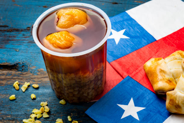 Chilean independence day concept. fiestas patrias. Chilean typical dish and drink on independence day party, 18 september. Mini empanadas, mote con huesillo, wine with toasted flor, chicha and tipical play emboque stock photo