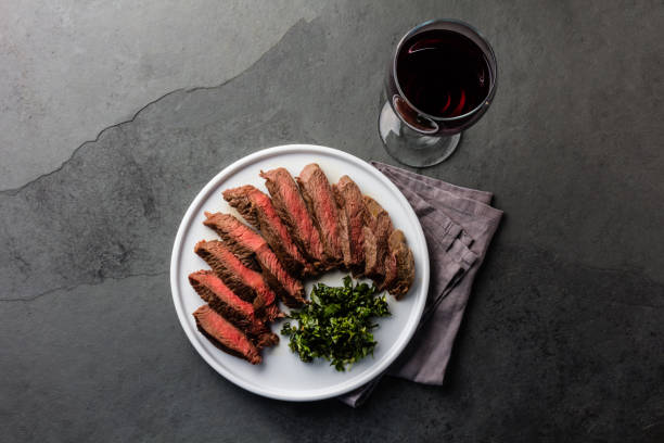 istock Medium rare beef steak served on white plate with red wine 840668700