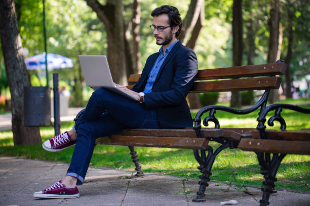 istock Young businessman works in park 840669086
