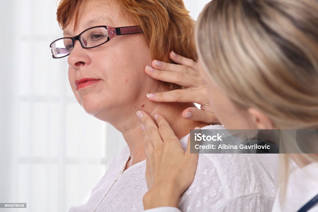 Doctor dermatologist examines birthmark of senior woman. Checking benign moles. Laser Skin tags removal Dermatologist Stock Photo