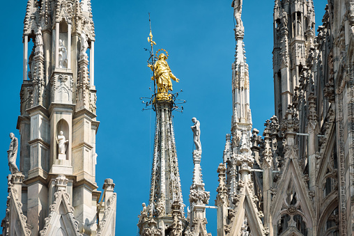 The Madonnina atop Milan Cathedral in Milan, italy. This statue was erected in 1762 at the height of 108.5 m. Milan Duomo is the largest church in Italy and the fifth largest in the world.