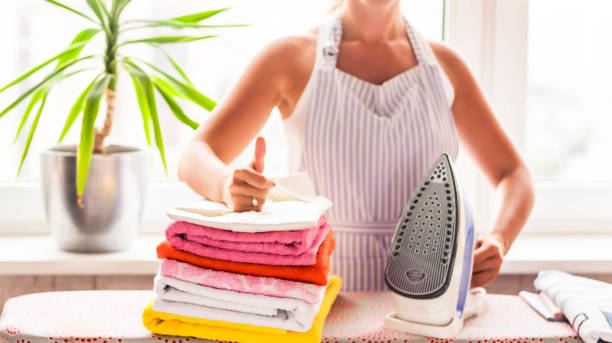 istock Ironing clothes on ironing board, ironed clothes ironing, laundry, clothes, housekeeping and objects concept - close up of ironed and folded shirts on table at home 840679120