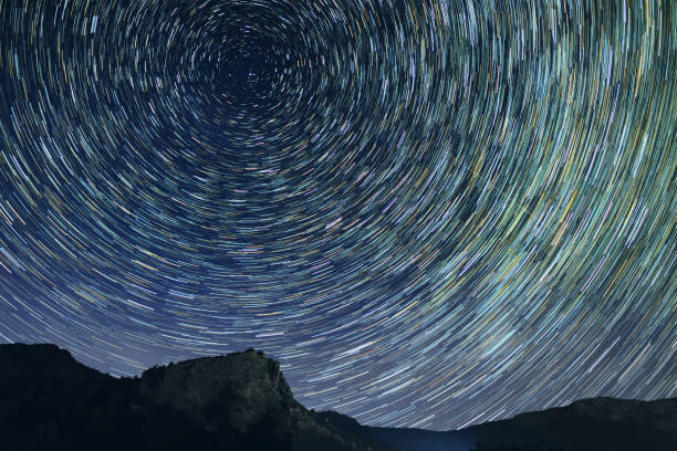 istock Star trails astro photography at dark night 840689108