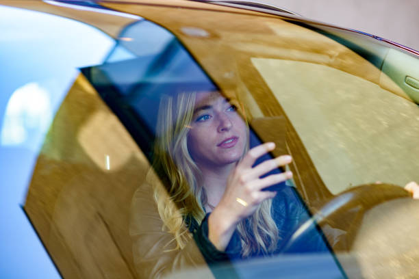 istock Young woman texting while driving car 840695882