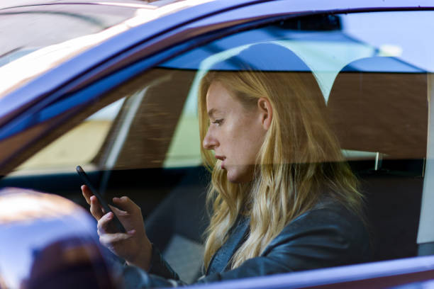 istock Young woman texting while driving car 840696328