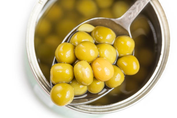 istock Pickled green peas in spoon on a can on white background 840700212