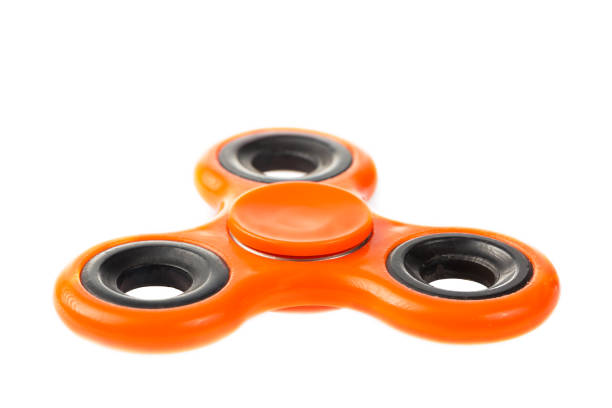istock Orange fidget spinner close up, stress relieving toy isolated on white background. 840700216