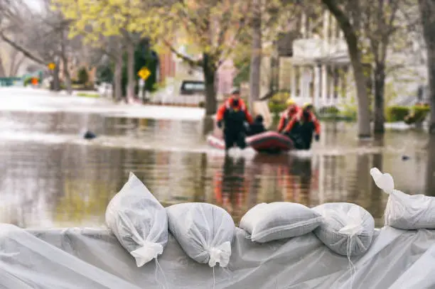 Photo of Flood Protection Sandbags with flooded homes in the background (Montage)