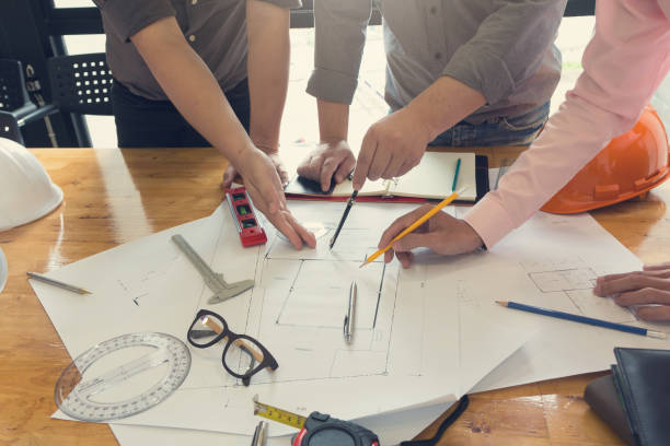 istock Engineer and Architect concept, Engineer Architects office team working and discussing house plan with blueprints and house model, Vintage Effect 840719416