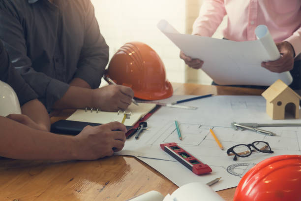 istock Engineer and Architect concept, Engineer Architects office team working and discussing house plan with blueprints and house model, Vintage Effect 840719504