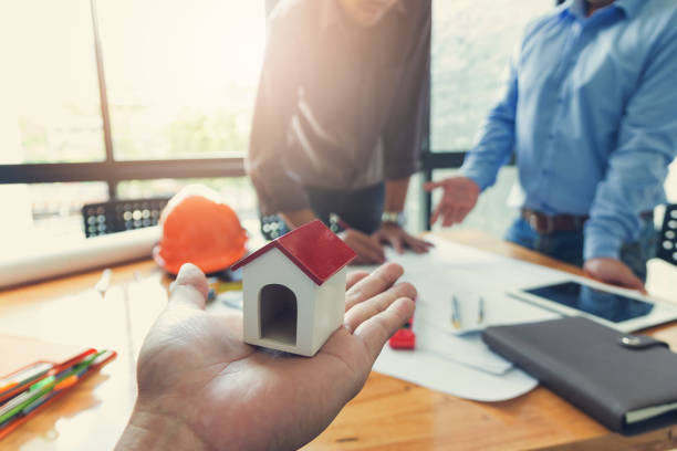 istock Engineer and Architect concept, Engineer Architects office team working and discussing with blueprints and house model, Vintage Effect 840719750