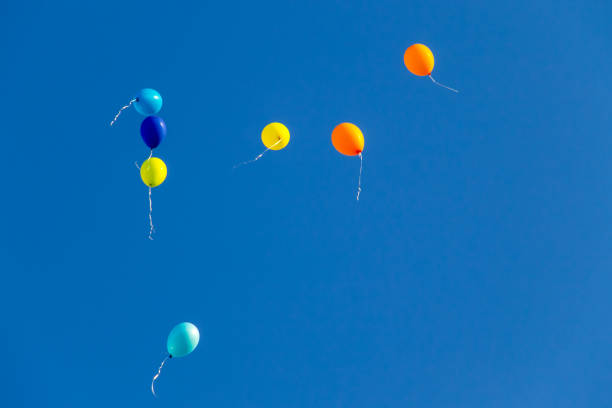 istock Colorful balloons flying in blue sky 840729368