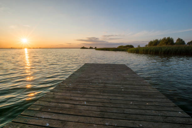 istock Sunset over the lake, view from a wooden bridge 840729810